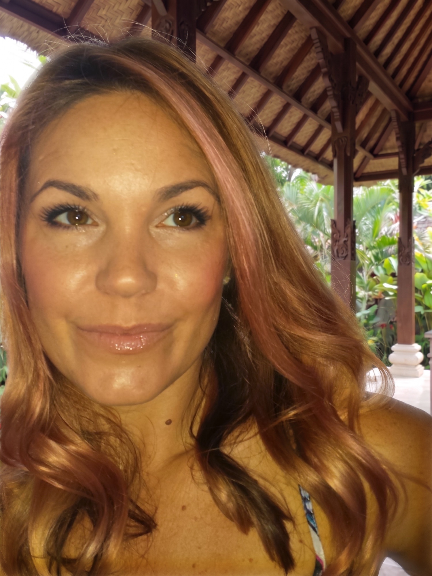 Sheri Cordi taking a selfie in an open-air pavilion in a tropical garden